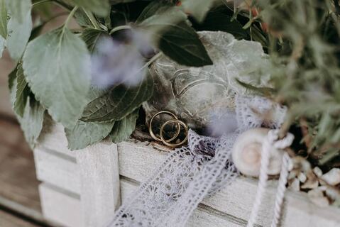 Hochzeitsringe und florale Details auf einer Ringschale